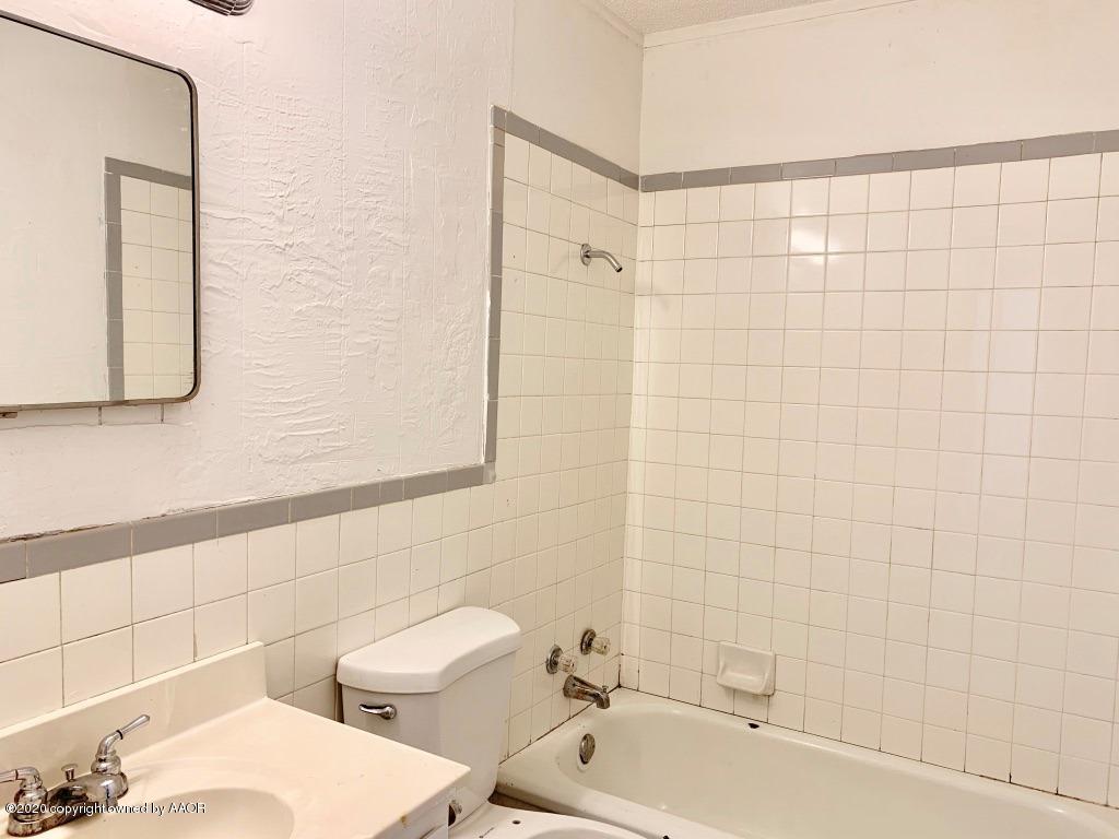 4131 South Harrison Street Amarillo, TX 79110 - Photo 6 of 8 a bathroom with a toilet a sink a mirror and bathtub