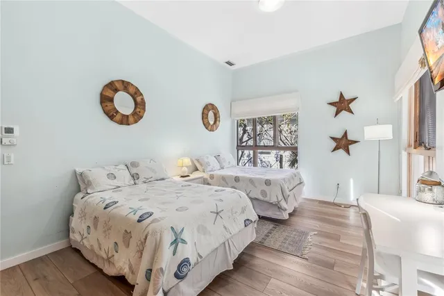 a bedroom with two beds and a chandelier
