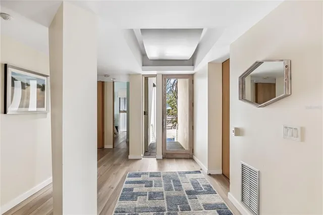 a view of a hallway with wooden floor and a bathroom