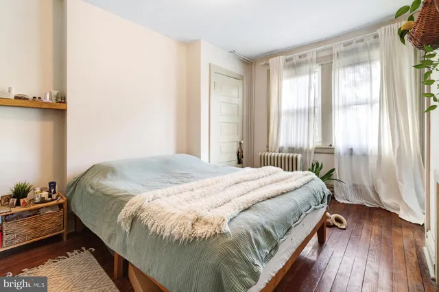 a large bed sitting in a bedroom next to a window