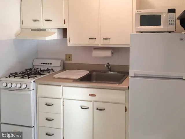 a kitchen with a white cabinets and white appliances