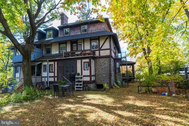 a view of a backyard with table and chairs and a large tree