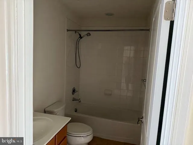 a bathroom with a granite countertop toilet a sink and shower