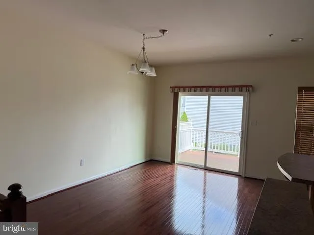 a view of livingroom with hardwood floor and hallway with windows