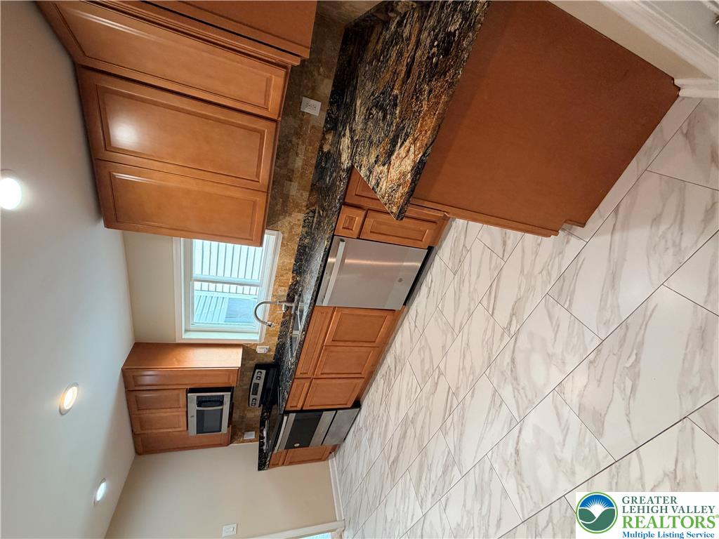 718 Ferry Street Easton, PA 18042 - Photo 9 of 37 Granite counters and stainless steel appliances adorn this efficient kitchen space.