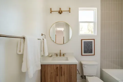 a bathroom with a granite countertop sink a mirror and a shower