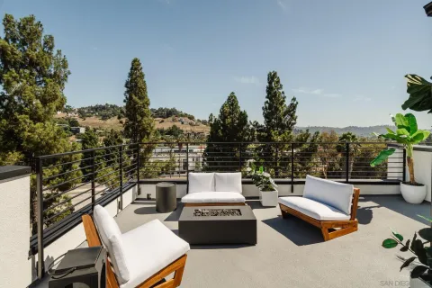 a roof deck with couches and potted plants