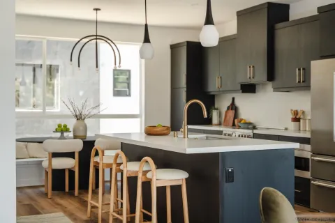 a kitchen with stainless steel appliances granite countertop a sink a stove and a dining table with wooden floor