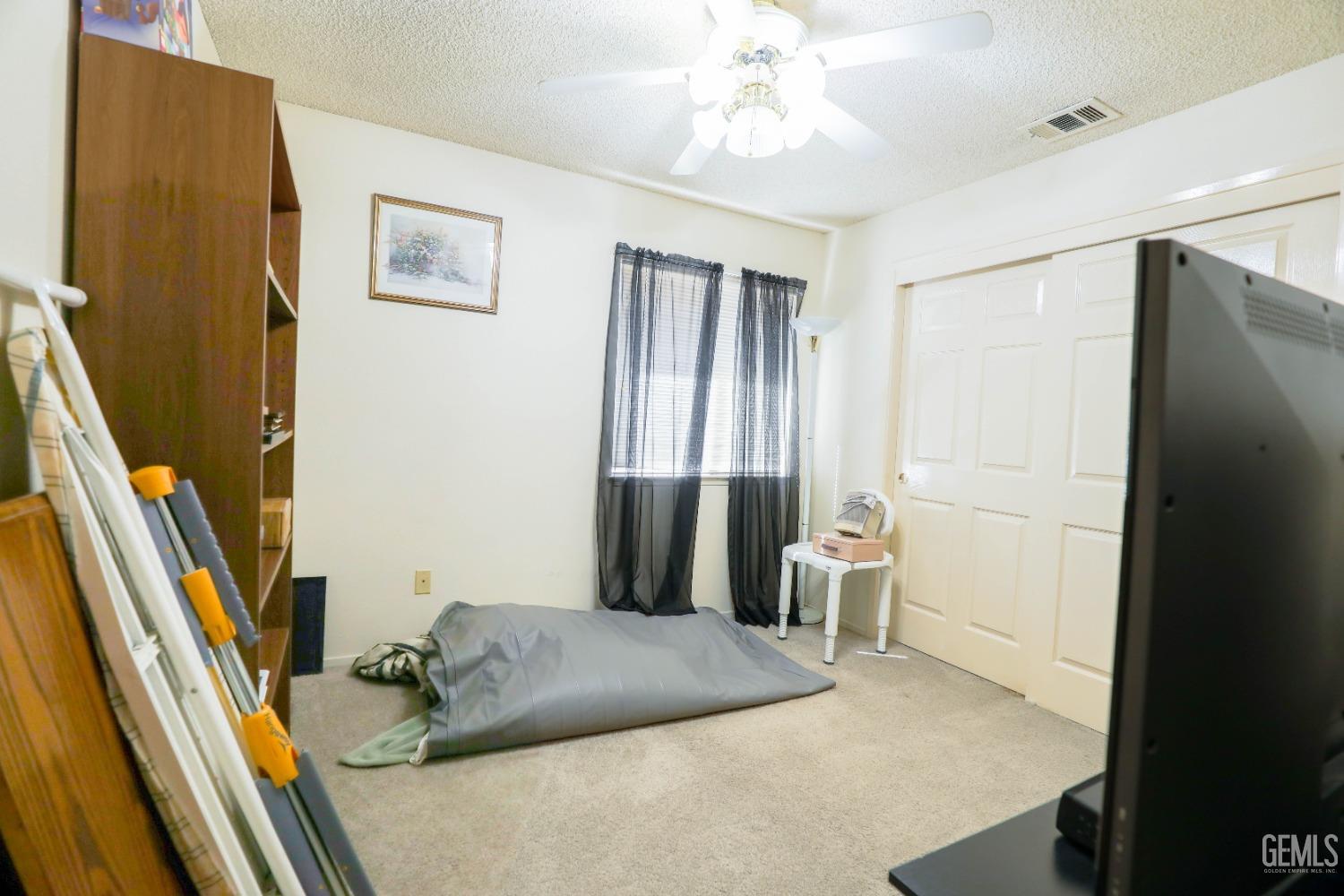 Undisclosed Address Bakersfield, CA 93313 - Photo 12 of 21 a bedroom with a bed and large windows
