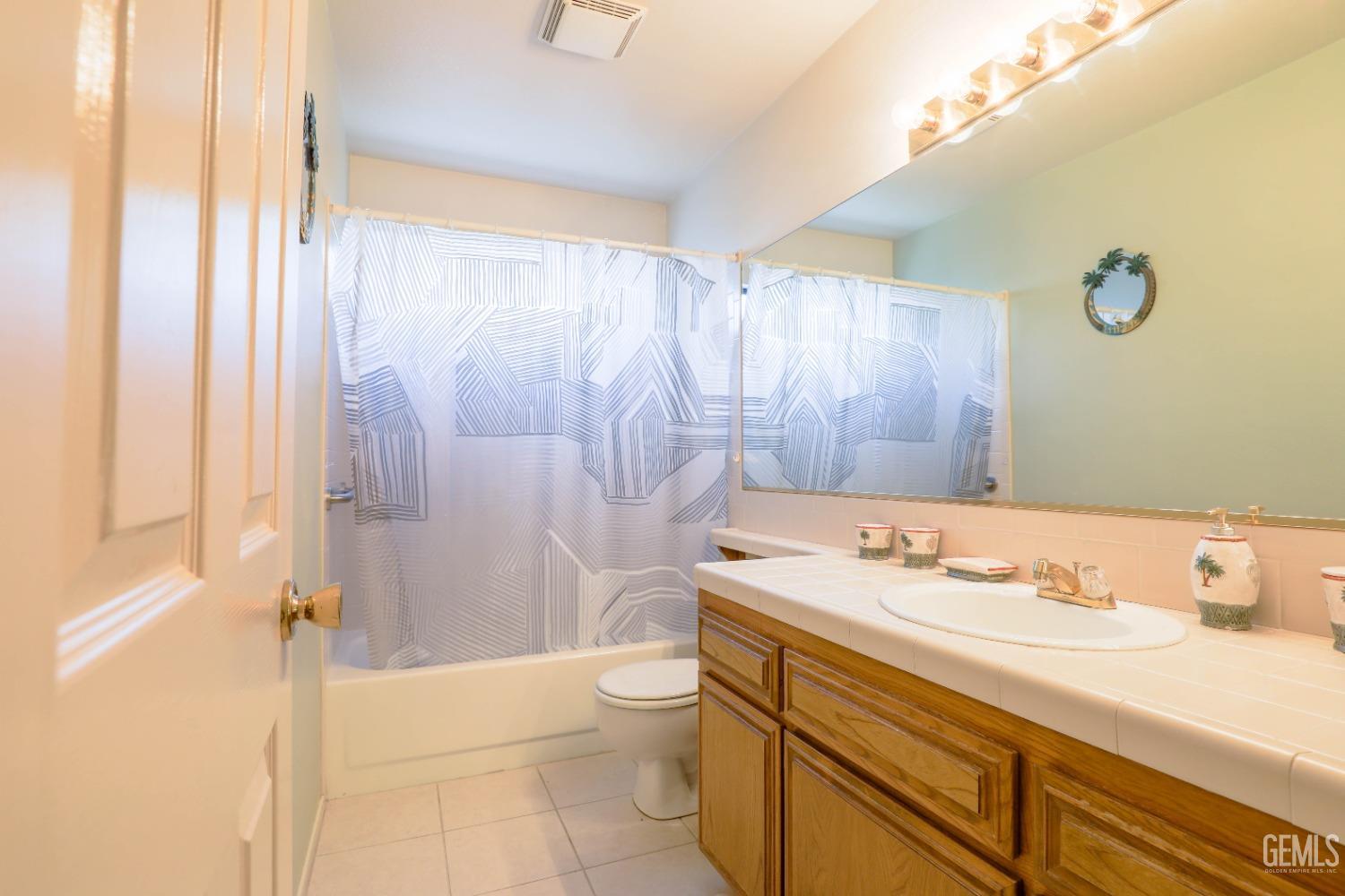 Undisclosed Address Bakersfield, CA 93313 - Photo 10 of 21 a bathroom with a sink a toilet and shower curtain
