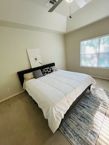 a bed sitting in a bedroom next to a window