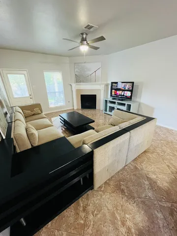 a living room with furniture a fireplace and a flat screen tv