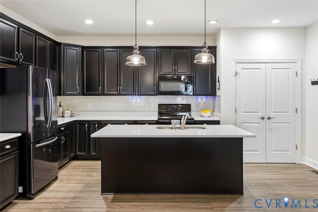 212 Lauradell Road Ashland, VA 23005 - Photo 28 of 35 a kitchen with kitchen island stainless steel appliances a sink cabinets and wooden floor