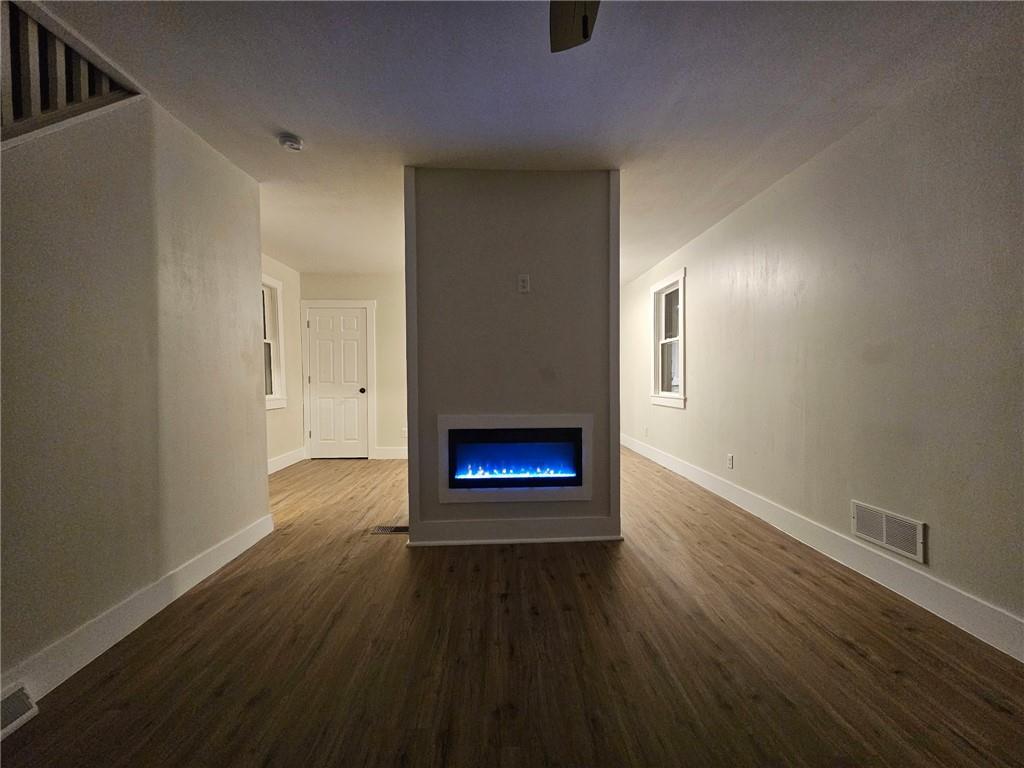 539 Walnut Street Vandergrift, PA 15690 - Photo 4 of 35 a view of an empty room with wooden floor a fireplace and a window