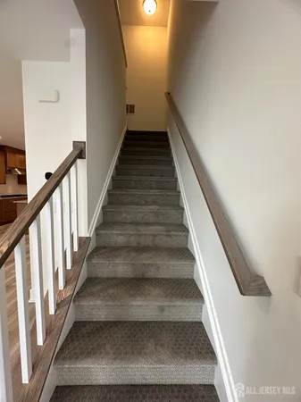 a view of an empty room with wooden floor and closet