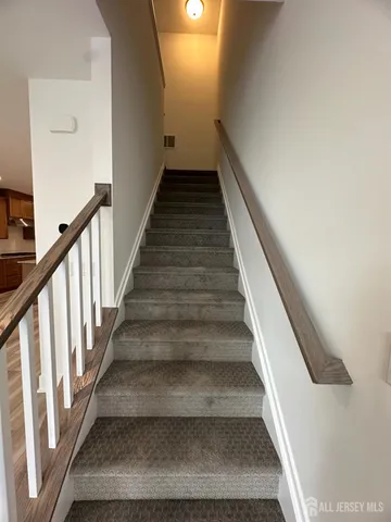 a view of an empty room with wooden floor and closet