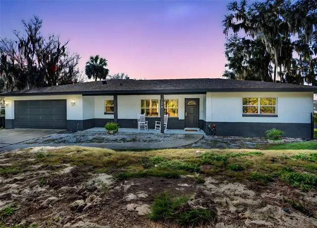 a view of a house with backyard and sitting area