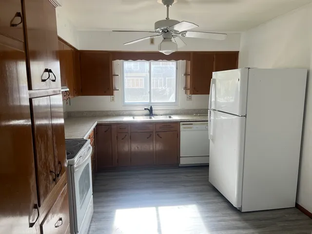 a kitchen with refrigerator cabinets and window