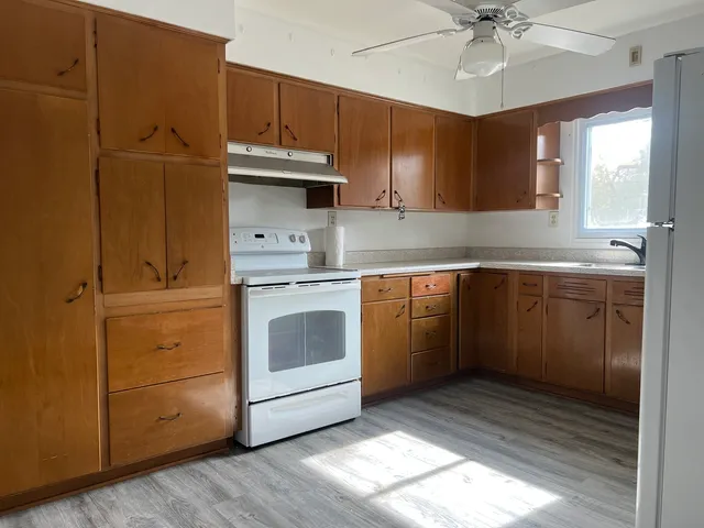 a kitchen with a stove cabinets and window