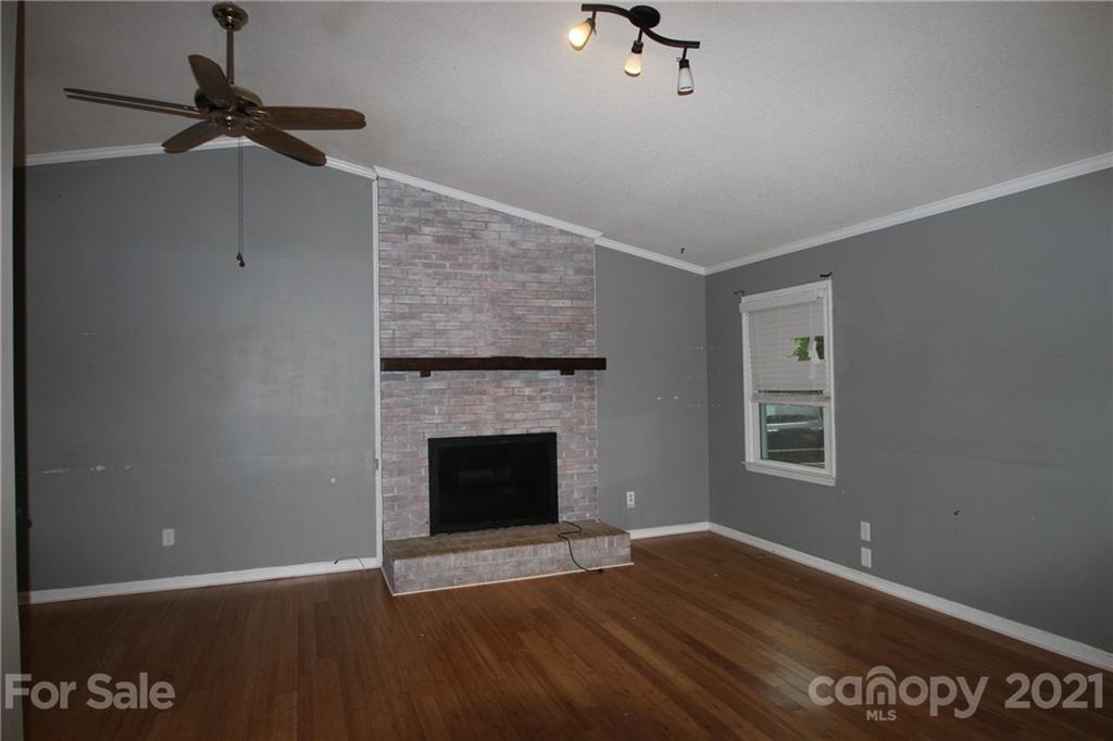 755 Shady Forest Road Clover, SC 29710 - Photo 3 of 12 a view of an empty room with wooden floor fireplace and a window