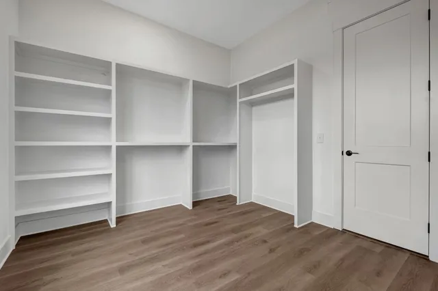 a view of an empty walk in closet and empty room
