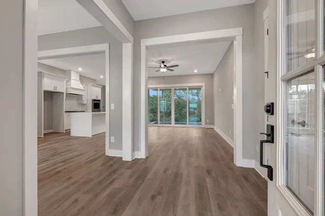 a view of a big room with wooden floor and a kitchen