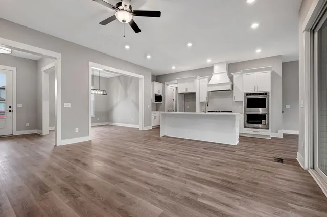 a view of a kitchen with wooden floor and a ceiling fan