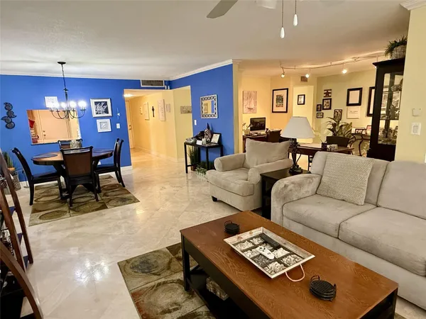 a living room with couches and a dining table with kitchen view