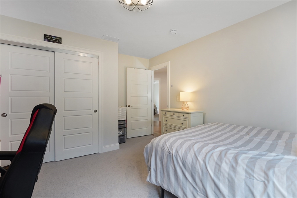 61 New Boston Road Sturbridge, MA 01566 - Photo 30 of 42 a bedroom with a bed and a chandelier
