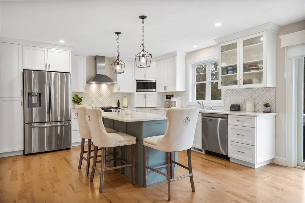 61 New Boston Road Sturbridge, MA 01566 - Photo 9 of 42 a kitchen with stainless steel appliances a refrigerator a stove a dining table and chairs with wooden floor