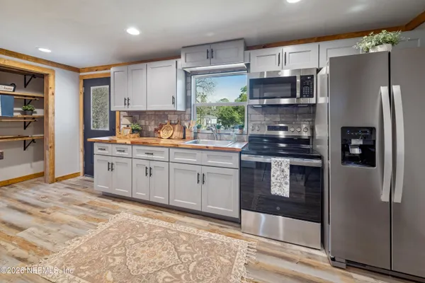 a large kitchen with stainless steel appliances granite countertop a lot of counter space and a large window