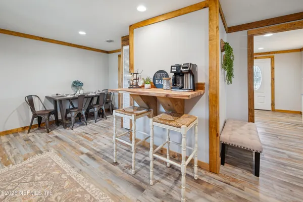 a view of a kitchen with kitchen island stainless steel appliances refrigerator a table and chairs