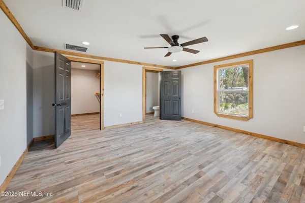 a view of empty room with wooden floor
