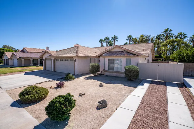 a front view of a house with a yard and potted plants
