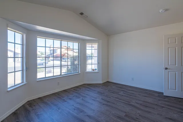 a view of a hallway with wooden floor and a bathroom