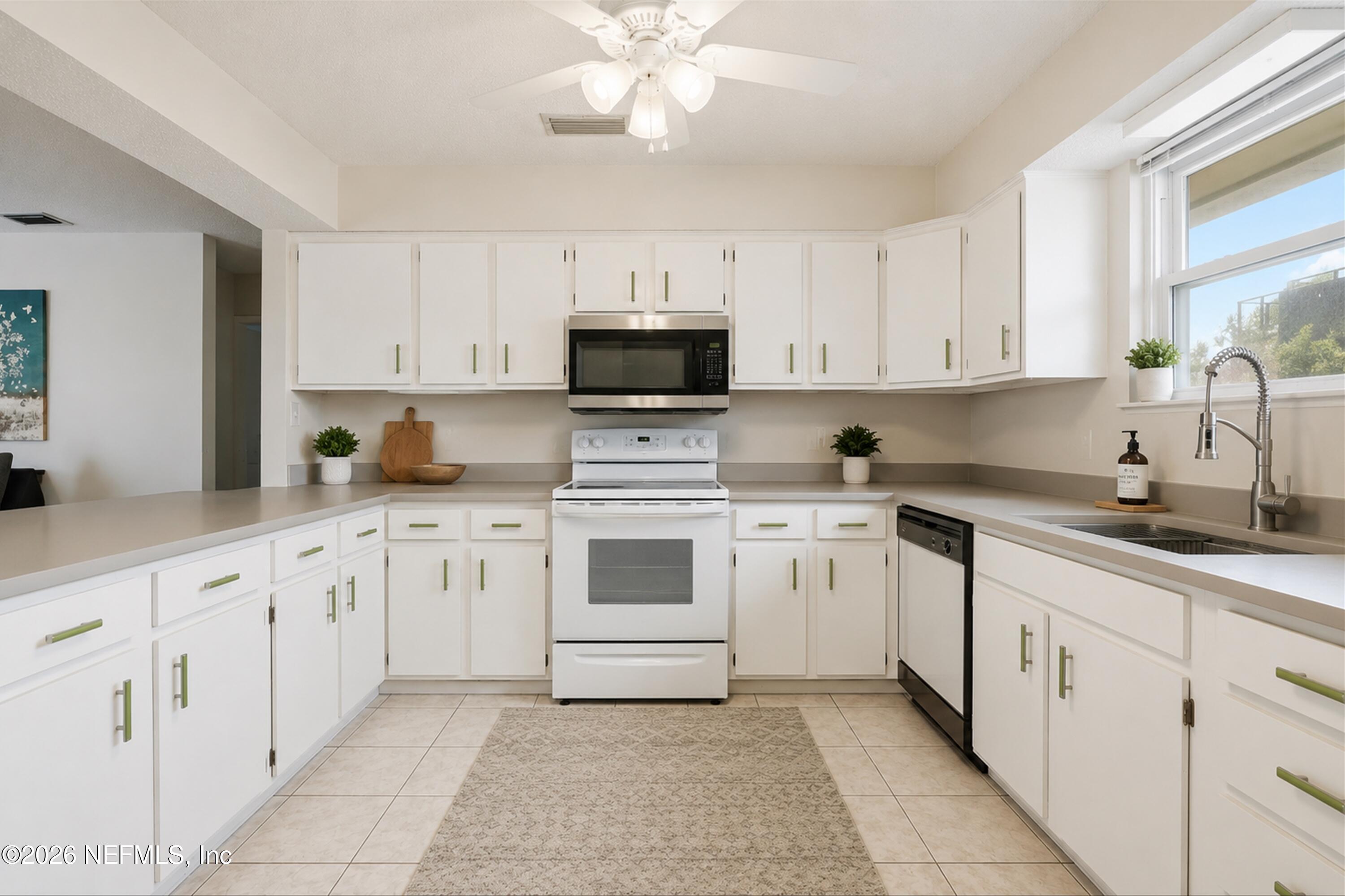 124 Hopkins Street Neptune Beach, FL 32266 - Photo 10 of 44 a kitchen with white cabinets and white appliances