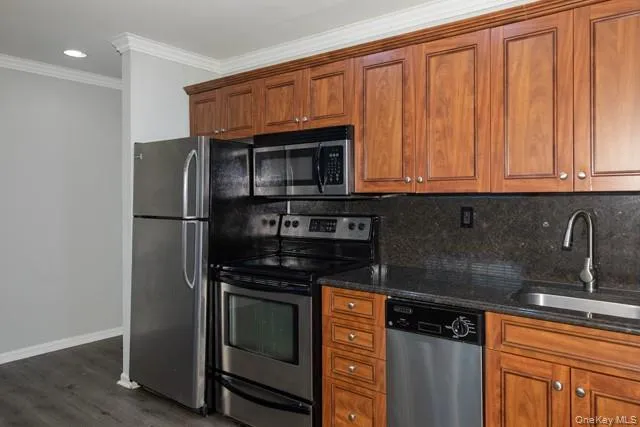 a kitchen with granite countertop a refrigerator stove and microwave