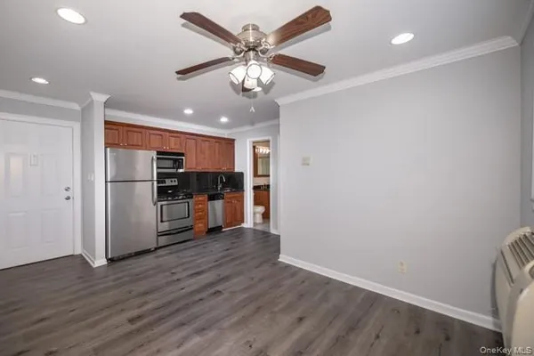 a view of kitchen with stainless steel appliances wooden floor and a refrigerator