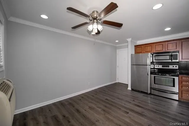 a view of kitchen with stainless steel appliances wooden floor and a stove top oven