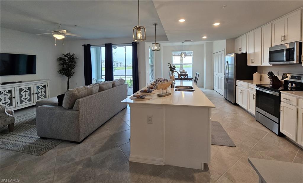 a living room with kitchen island furniture and a flat screen tv