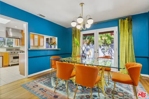 a view of a dining room with furniture a chandelier and wooden floor