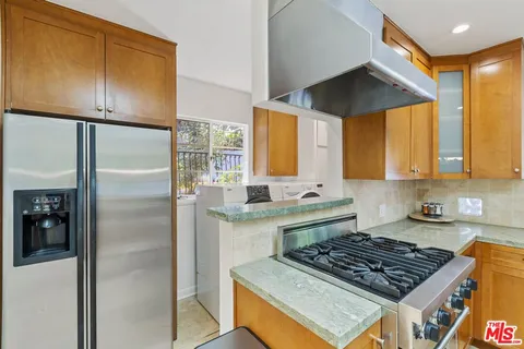 a kitchen with stainless steel appliances granite countertop a refrigerator and a sink
