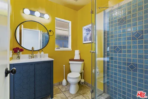 a bathroom with a toilet sink vanity and mirror