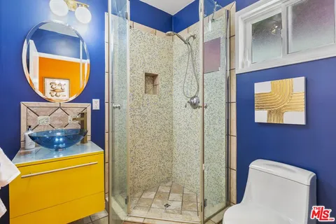 a bathroom with a toilet mirror and vanity