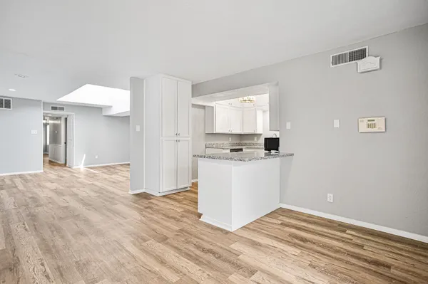 a view of an empty room with wooden floor and a fireplace