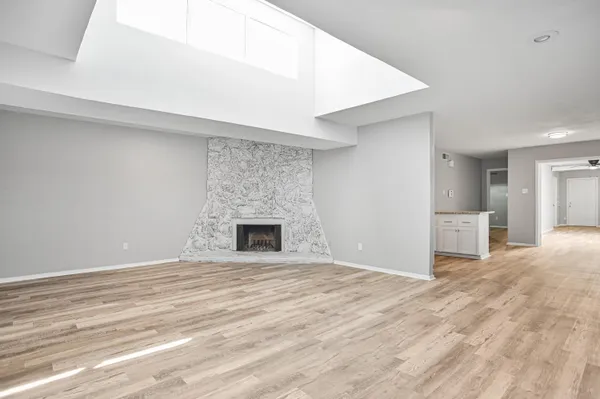 a view of empty room with wooden floor and fireplace
