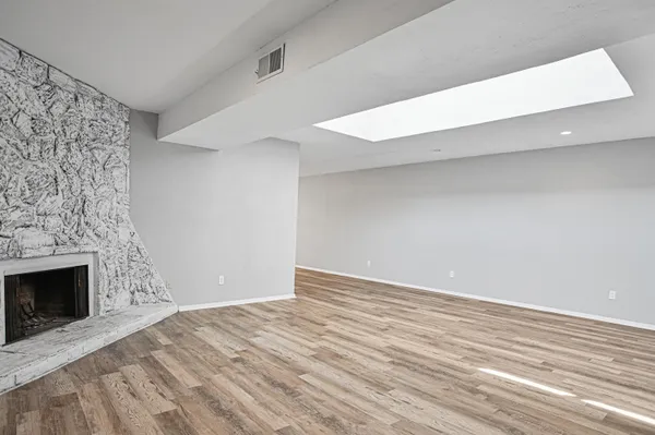 a view of empty room with wooden floor and fireplace