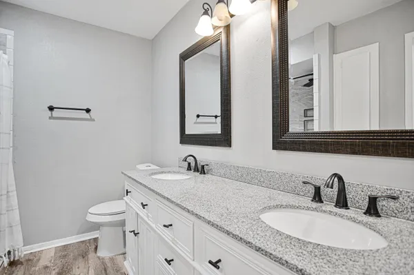 a bathroom with double sink and a mirror
