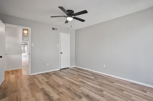 a view of empty room with wooden floor