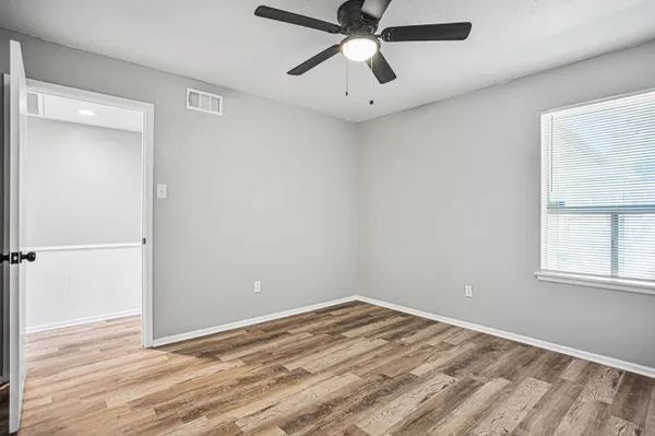 a view of empty room with wooden floor